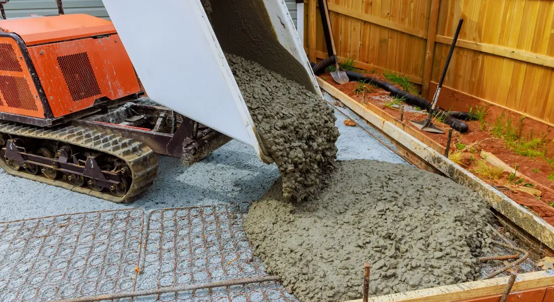 Fresh concrete being poured and screeded on site