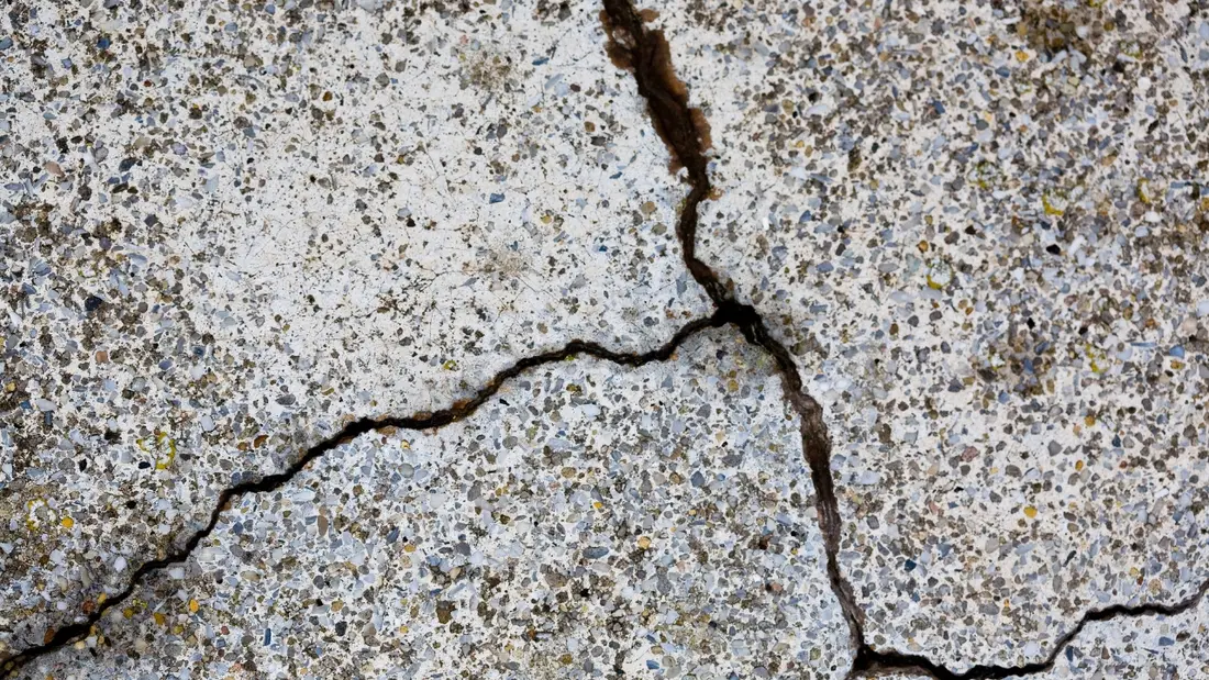 Flaking and spalling on an outdoor concrete driveway surface