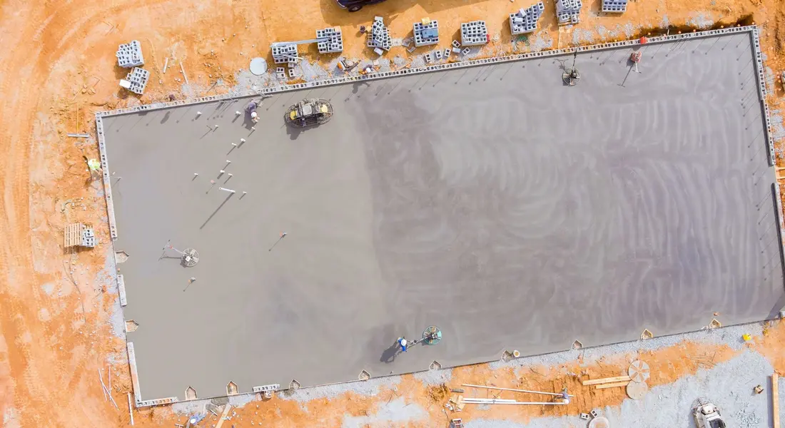 A freshly poured concrete slab being finished
