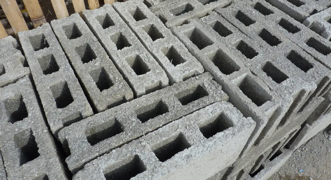 A concrete block retaining wall holding back a sloped garden bed