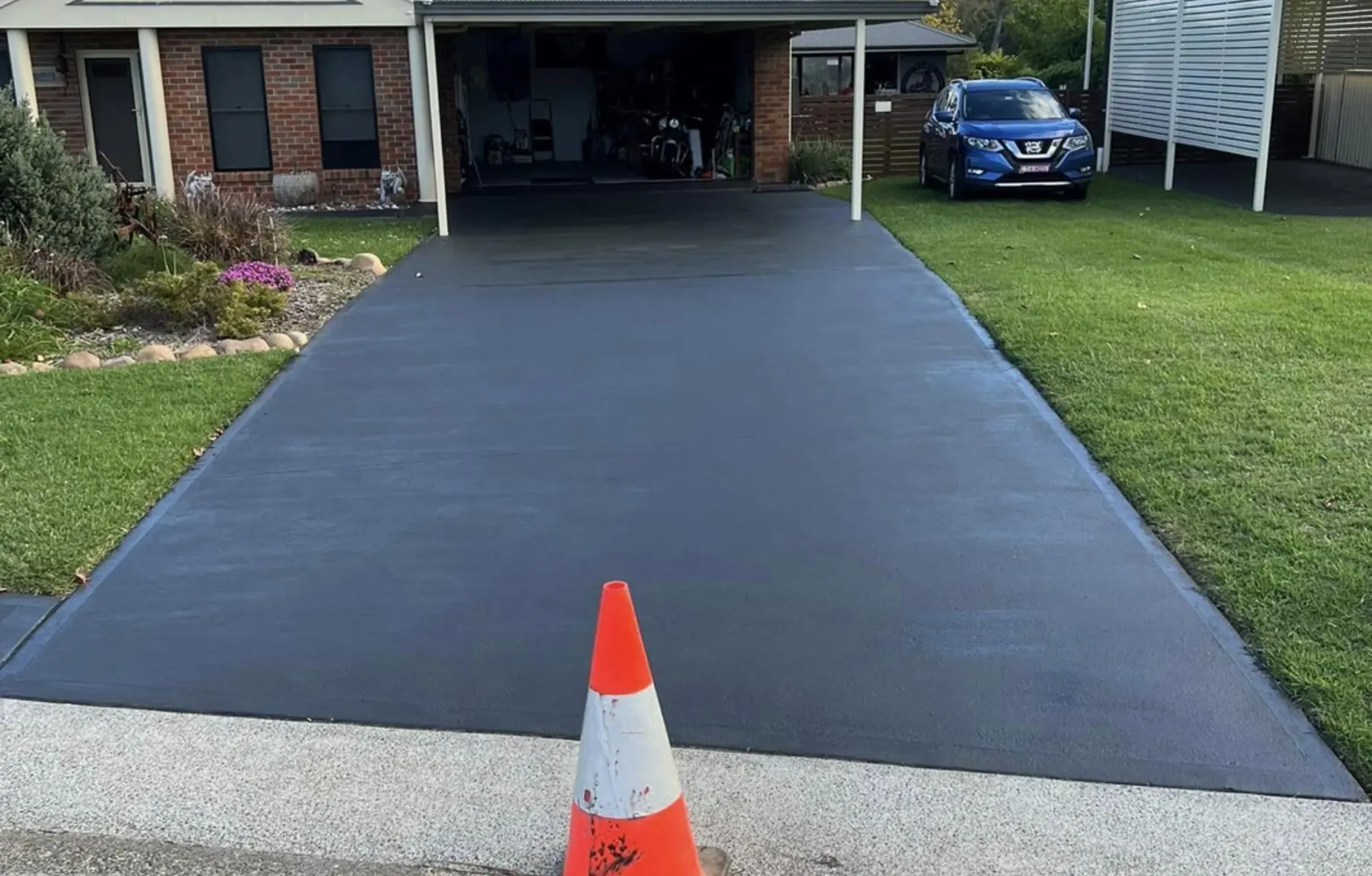 A freshly poured charcoal concrete driveway by Con Ops