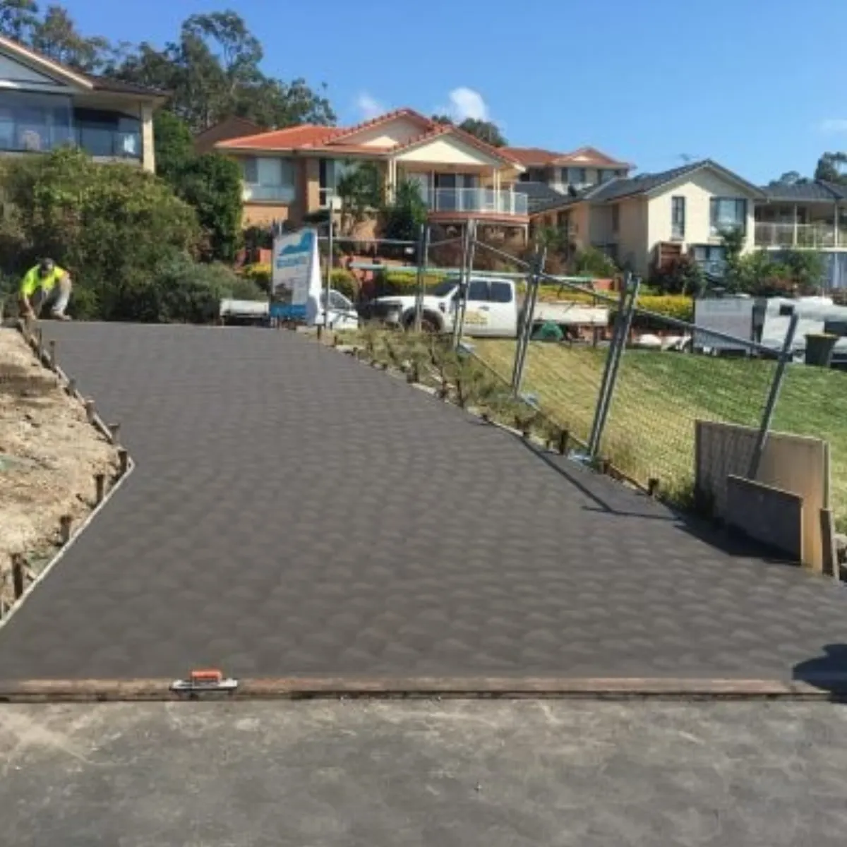 A freshly poured concrete driveway on a residential street